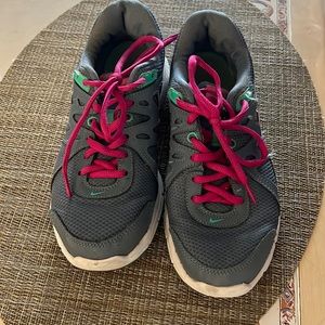 Grey Nike sneakers with pink laces.